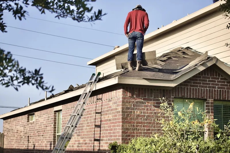 Professional roofer working on a residential roof in Vamo